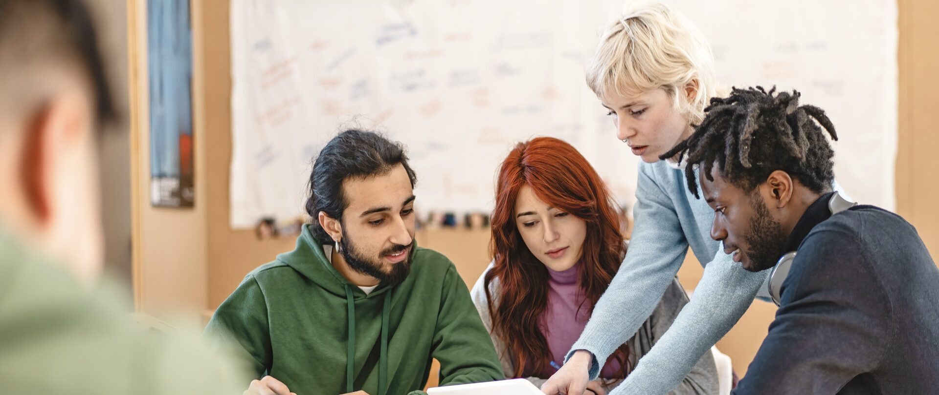 Group of diverse college students working together on a project in a classroom setting Teamwork, diversity, and collaboration, with students engaged in discussion and study activities.