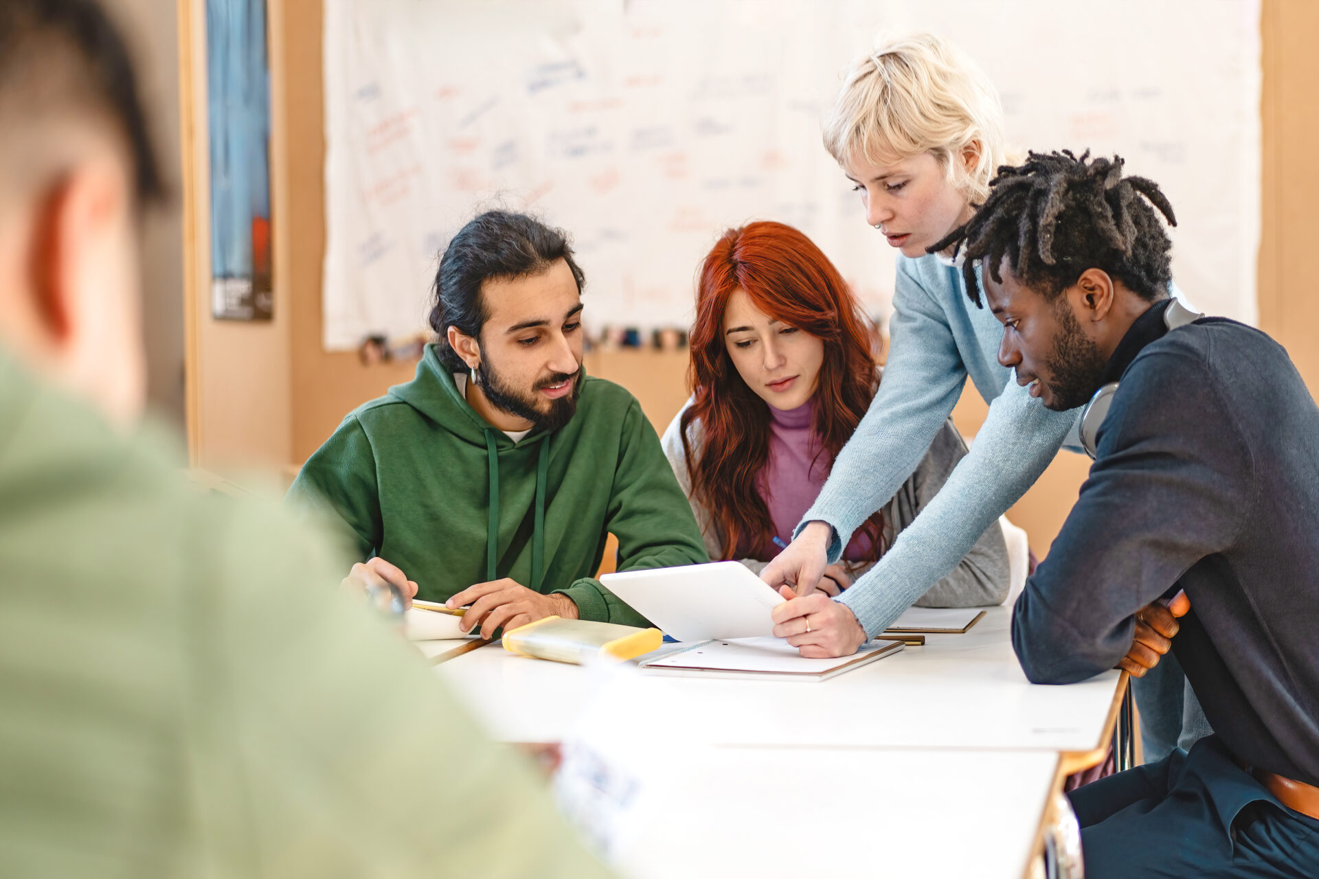 Group of diverse college students working together on a project in a classroom setting Teamwork, diversity, and collaboration, with students engaged in discussion and study activities.