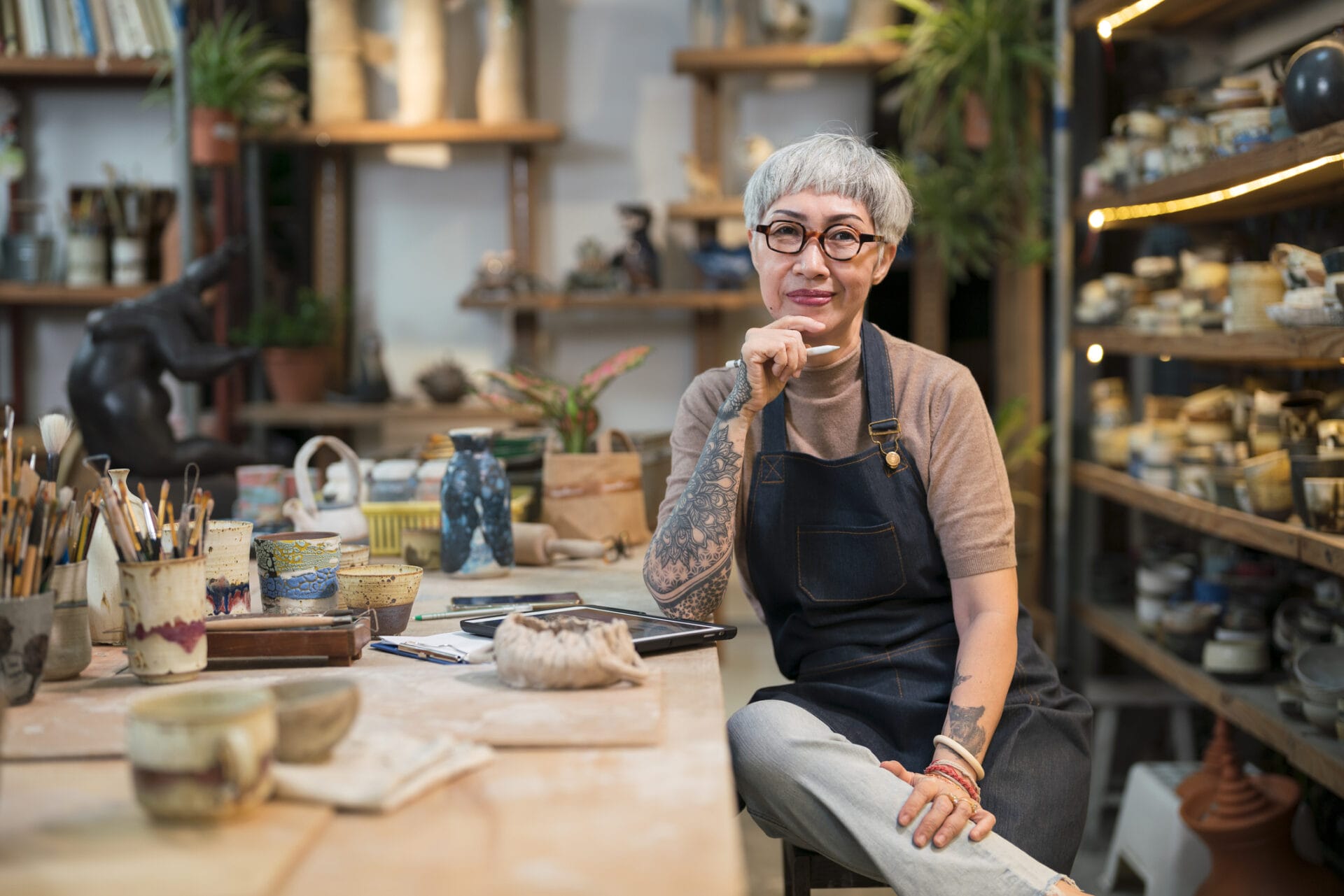 Portrait Female potter sitting in her studio.