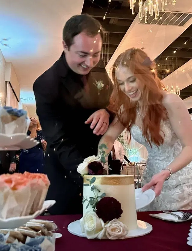 a wedding couple cutting their cake