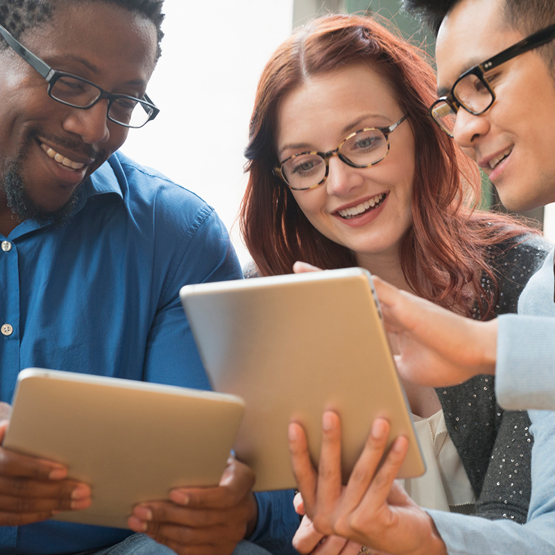 3 colleagues looking at tablet screens