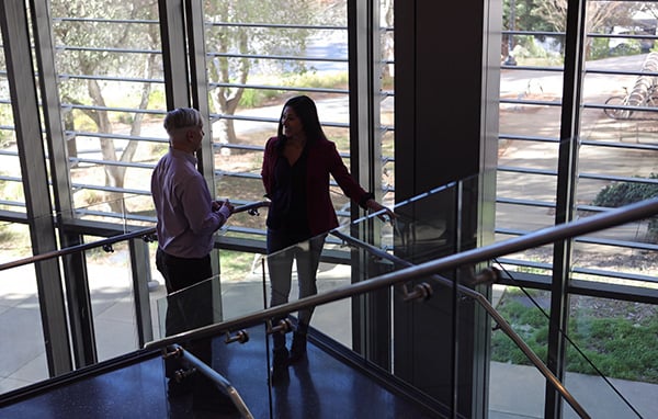 Pari and Katon talking on stair platform