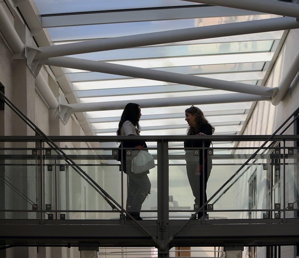 two people talking on a bridge